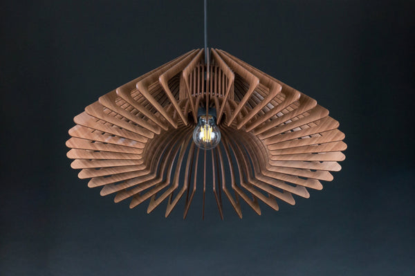 Halo wooden pendant light in walnut – wide flared shade of angled slats, lit, dark background