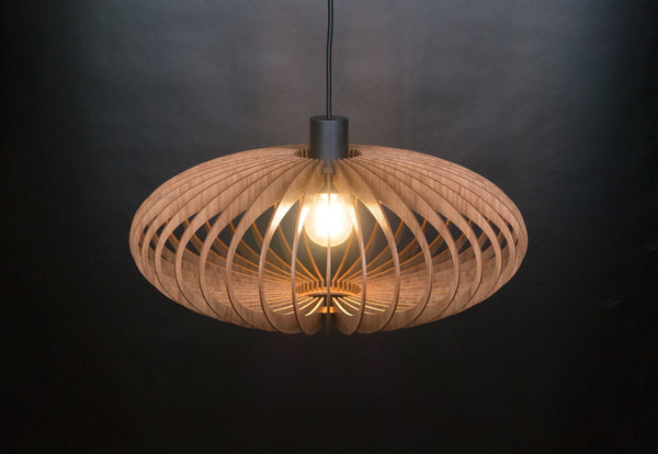 Ellipse wooden pendant light – oval shade of curved slats, lit with a warm glow against a dark background