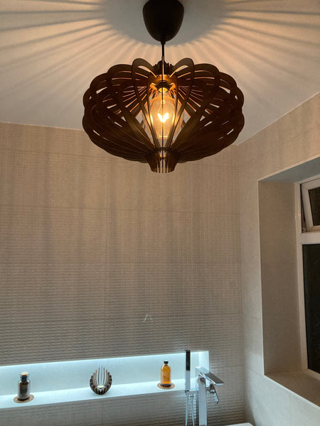Customer photo (walnut): Medusa wooden pendant light, lit, in a bathroom